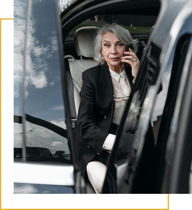 A woman sitting in the back of a car talking on her phone.